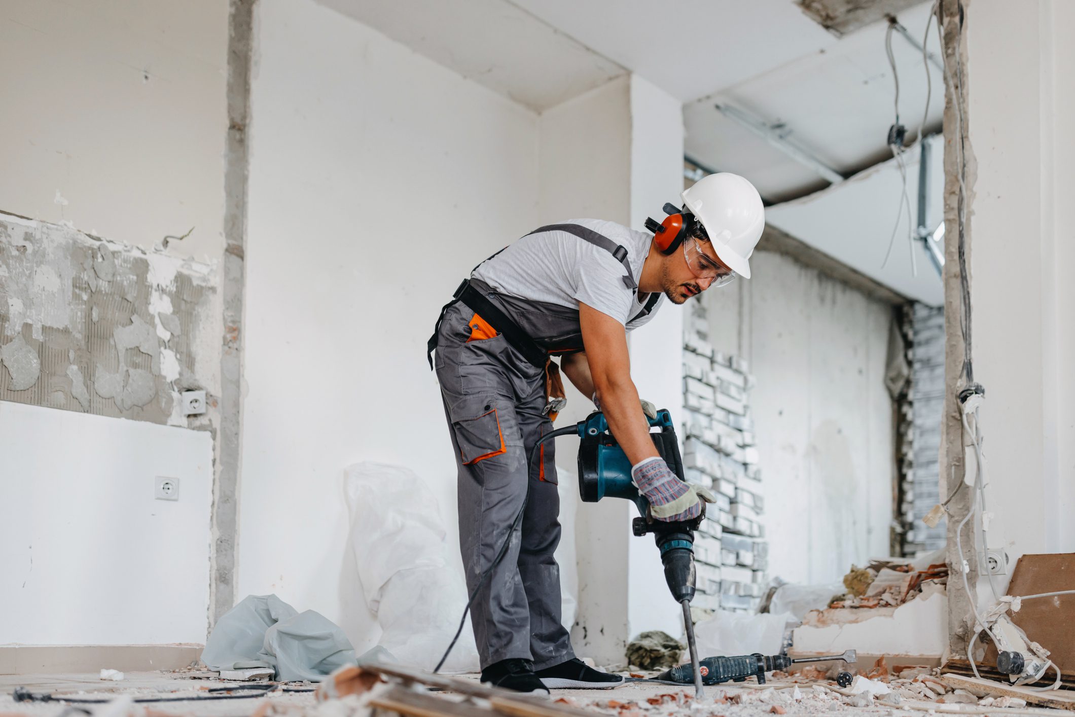 Construction worker using a jackhammer indoors