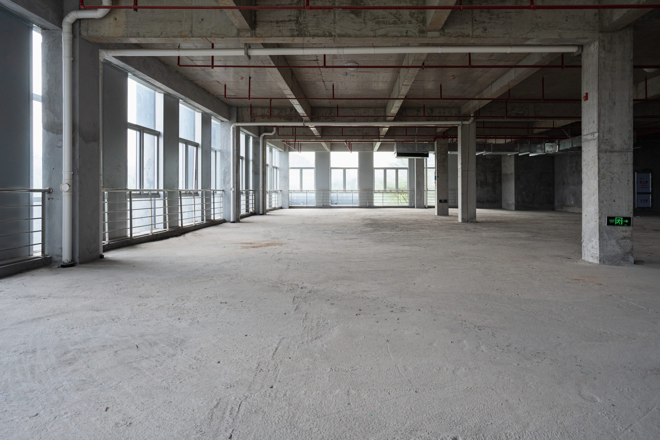 Open construction space with exposed ceiling beams.